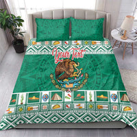 Green bedding set with eagle emblem and colorful Aztec trim, shown on a bed with pillows