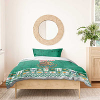 Green bedding set with eagle emblem center, Aztec border pattern, on a bed