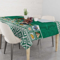 Green tablecloth with Aztec geometric border, coat of arms, and ornate icons
