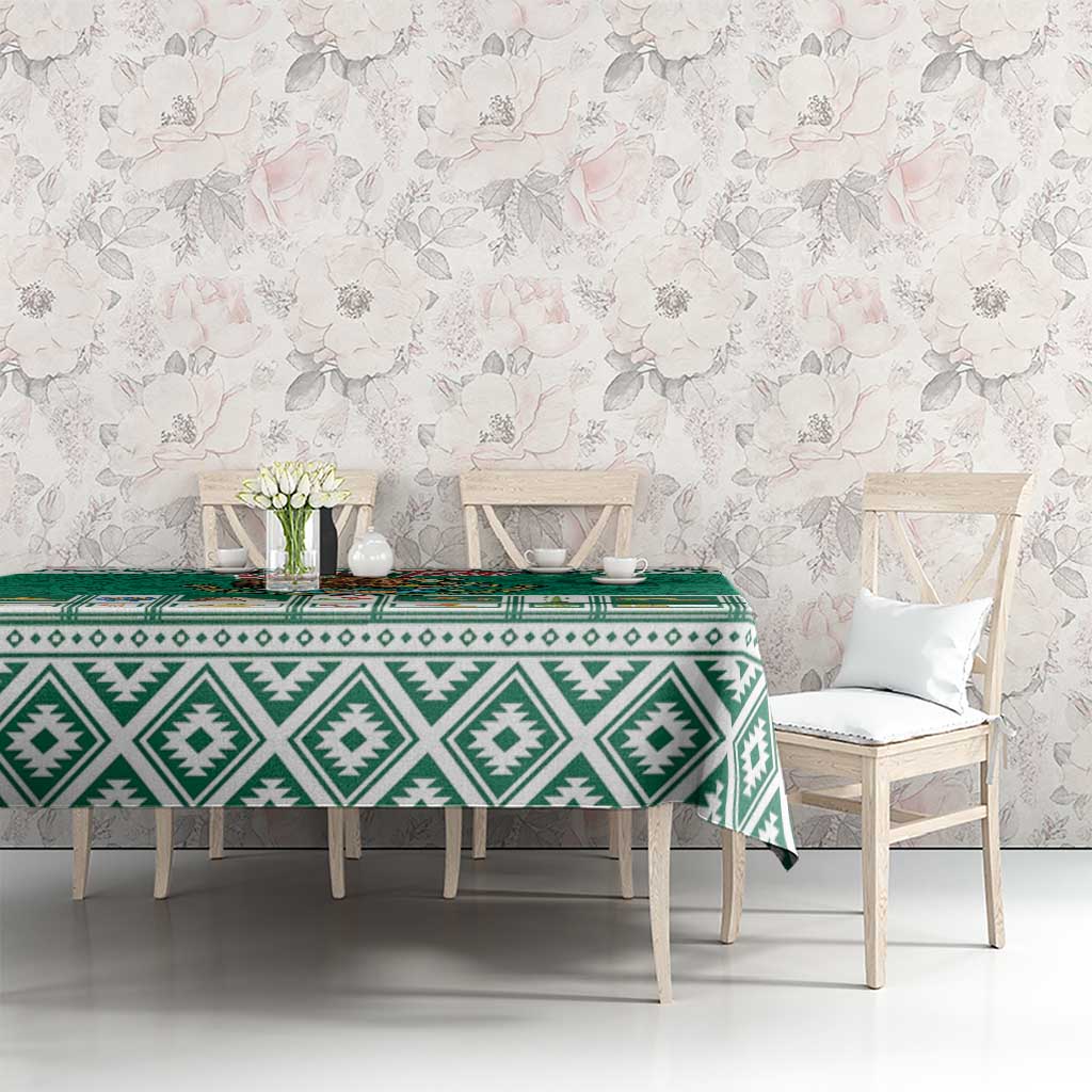 Green tablecloth with white Aztec geometric print and repeating decorative icons