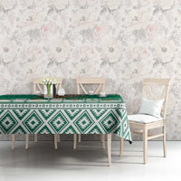 Green tablecloth with white Aztec geometric print and repeating decorative icons