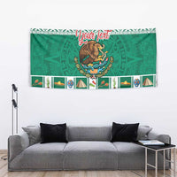 Green rectangular tapestry with central coat of arms and festive Aztec-style pattern band