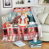 Christmas throw blanket on bed, red plaid edge, saint in robe with tree and gifts