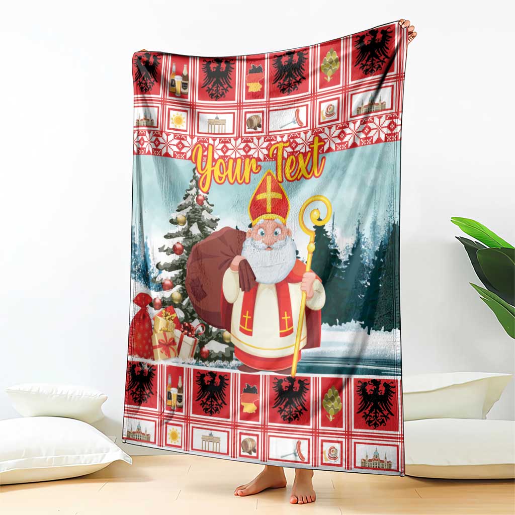 Christmas blanket with red plaid border and saint holding a staff, blue snowy scene