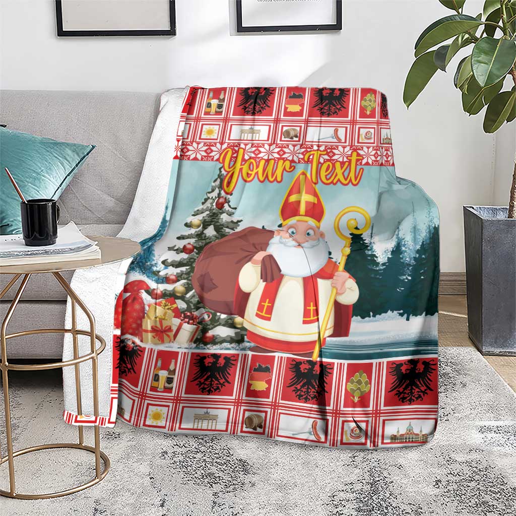 Personalized Christmas blanket on chair, red plaid trim, saint holding staff, snowy trees