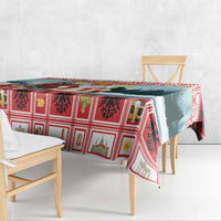 Red plaid Christmas tablecloth with blue forest panel, draped over a small dining table