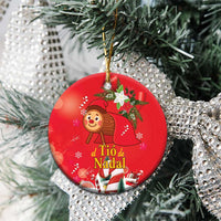 Red round ceramic Christmas ornament with gold hanging loop on tree branches