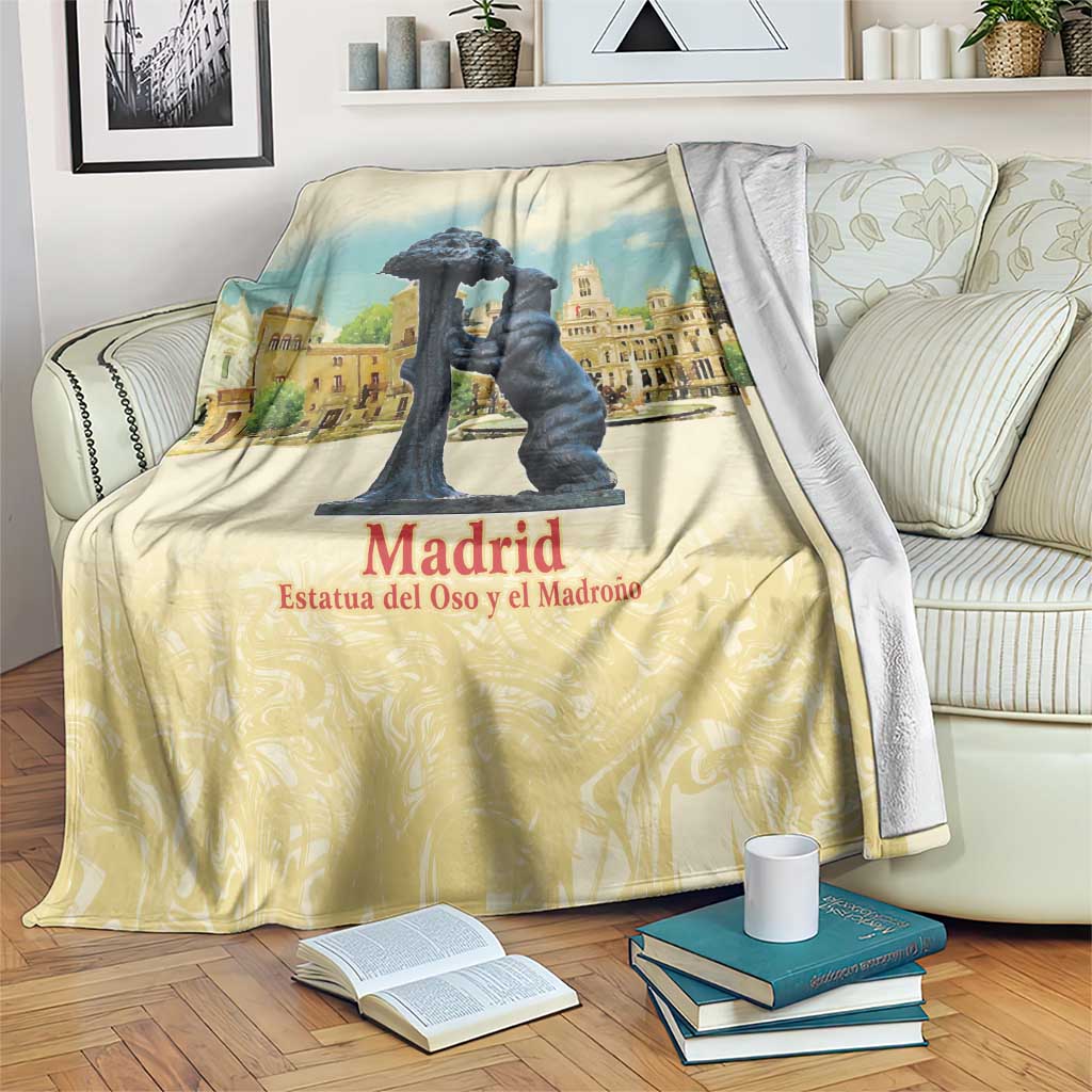Madrid watercolor blanket with dark statue print and “Madrid” text, draped on sofa