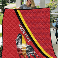 Red quilt blanket with black and yellow diagonal stripe and lion graphic in center