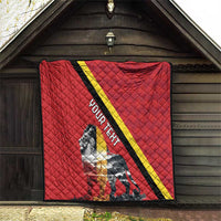 Red quilt blanket hanging outdoors with black and yellow diagonal stripe and lion design