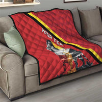 Red quilt blanket on gray sofa with black and yellow diagonal stripe and lion artwork