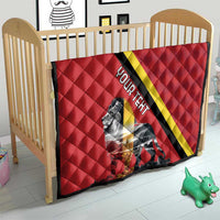 Red quilt blanket on wooden crib with black and yellow diagonal stripe and lion graphic