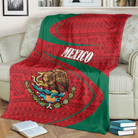 Mexico coat of arms blanket on couch, red and green folk stripes with eagle emblem