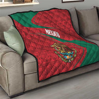 Mexico flag quilt on a gray sofa, red and green geometric pattern with center coat of arms