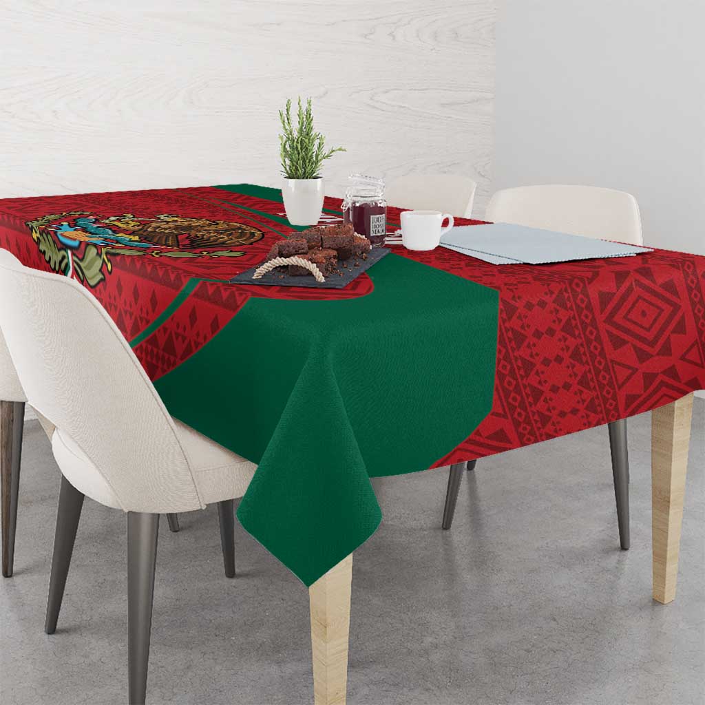 Red and green folk-pattern tablecloth draped over dining table with dinnerware
