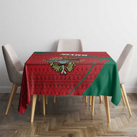 Red and green folk-pattern tablecloth on rectangular table with matching drape