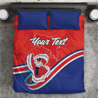 Top view bedding set: two blue pillows and red-blue duvet; “Your Text” with Costa Rica map artwork