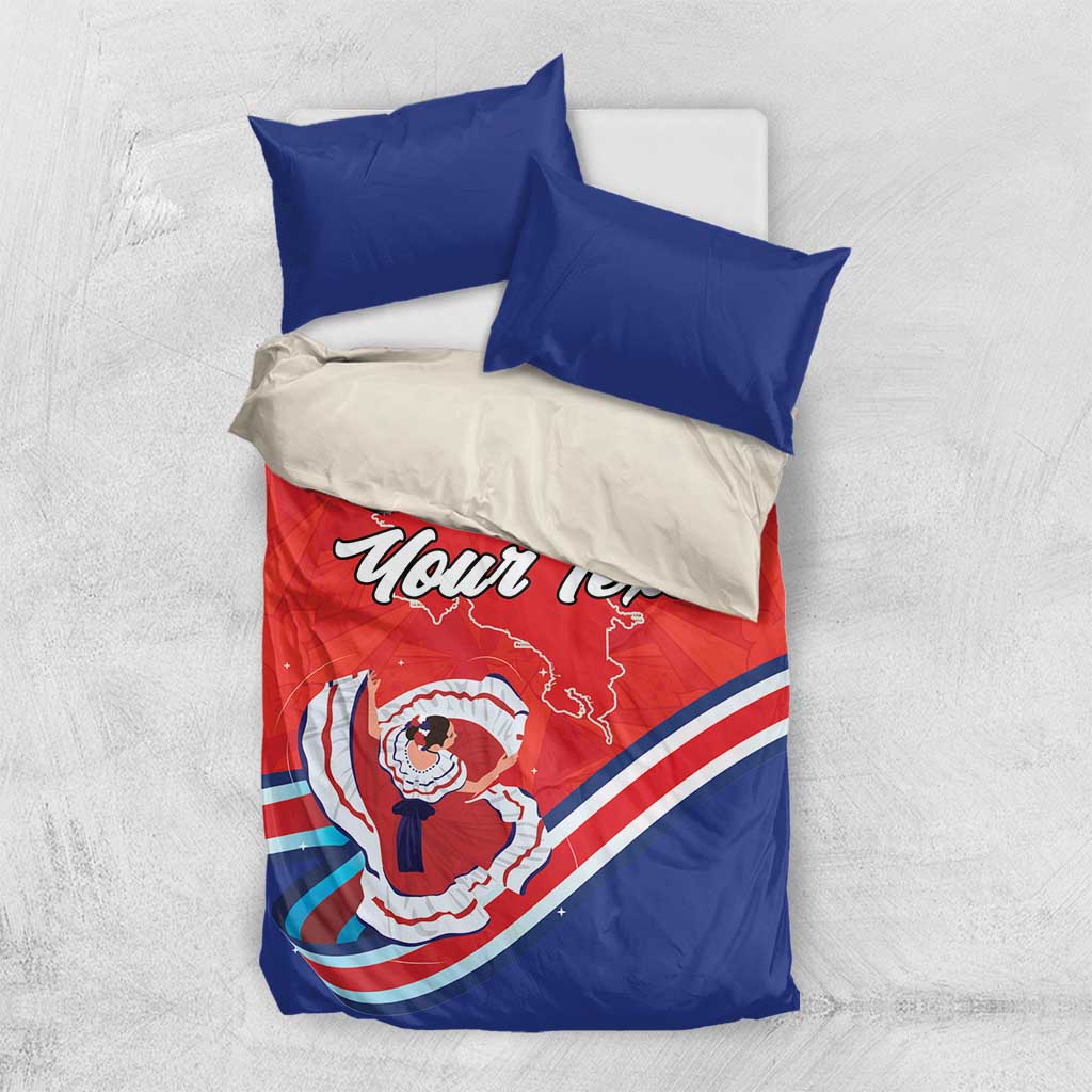 Red and blue bedding set with two blue pillows; duvet features Costa Rica map and dancer graphic