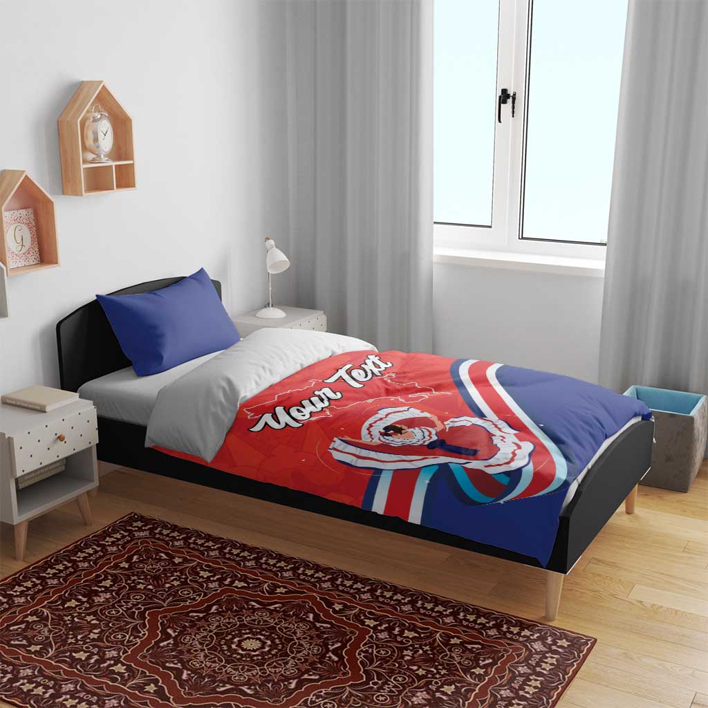 Red and blue duvet and pillow set on a bed frame; “Your Text” and Costa Rica folk dancer artwork