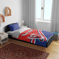 Red and blue duvet and pillow set on a bed frame; “Your Text” and Costa Rica folk dancer artwork