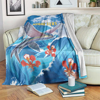 Blue sea-themed fish flying blanket with red coral flowers and wave pattern, folds over couch