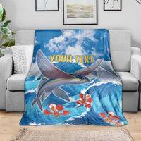 Blue wave and fish blanket with red coral flowers and yellow "YOUR TEXT" center, draped on sofa
