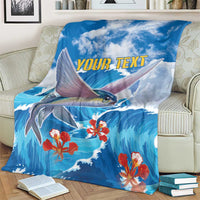 Blue fish and wave blanket with red coral flowers and yellow "YOUR TEXT", spread over striped couch