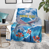 Blue sea fish blanket with red coral flowers and yellow "YOUR TEXT" panel, laid on gray sofa