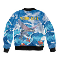 Blue bomber jacket back with ocean waves and flying fish graphic, black rib collar and hem.
