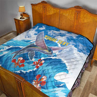 Personalized blue quilt on a bed with flying fish graphic, red flowers, 'YOUR TEXT'