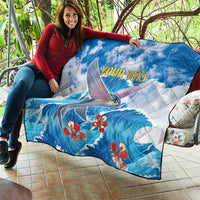 Personalized blue quilt draped over couch with flying fish and red blossoms, 'YOUR TEXT'