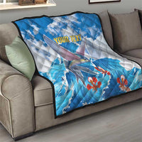 Personalized blue quilt on sofa with flying fish design, red flowers, 'YOUR TEXT' text