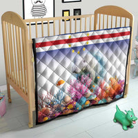 Quilt in baby crib with Cape Verde flag stripes, stars, and manatee coral reef print