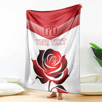 Custom rugby-style blanket draped over couch with red/white rose and “YOUR TEXT”