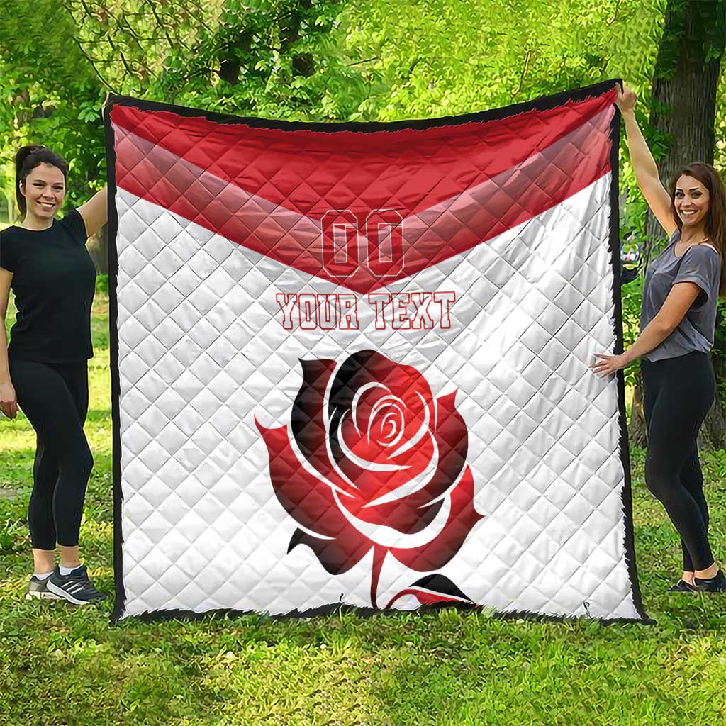 Red and white quilt blanket with “YOUR TEXT” and rose design, shown on grass