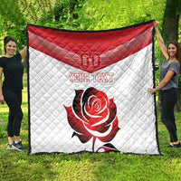 Red and white quilt blanket with “YOUR TEXT” and rose design, shown on grass