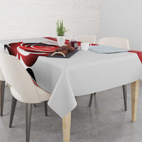 White tablecloth with red rose and black petal motifs, draped across a dining table