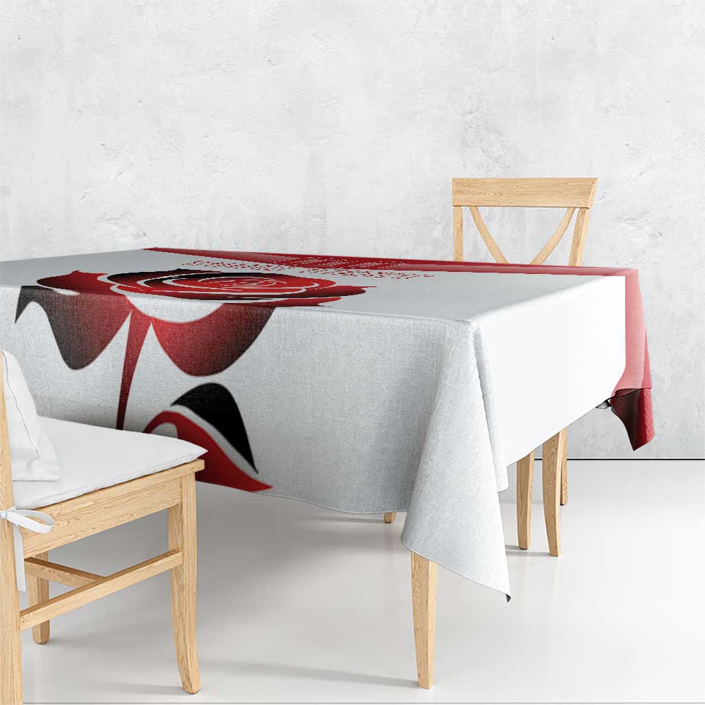 Rectangular tablecloth with bold red flower pattern and black accents, hanging over table