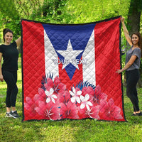 Puerto Rico flag quilt spread on grass, red quilt with blue triangle and flower print