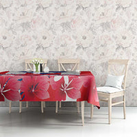 Red hibiscus floral tablecloth on a table with four chairs and decor