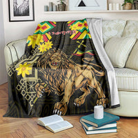 Black lion folk blanket with colorful chevrons and yellow flowers, draped over a couch.