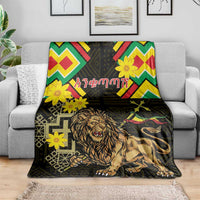 Black lion portrait folk blanket with colorful chevrons and yellow flowers, spread on a sofa.
