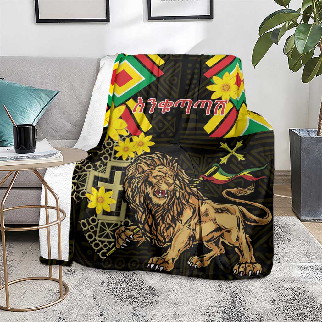 Black lion of Judah folk blanket with chevrons and yellow flowers, laid over a living room seat.