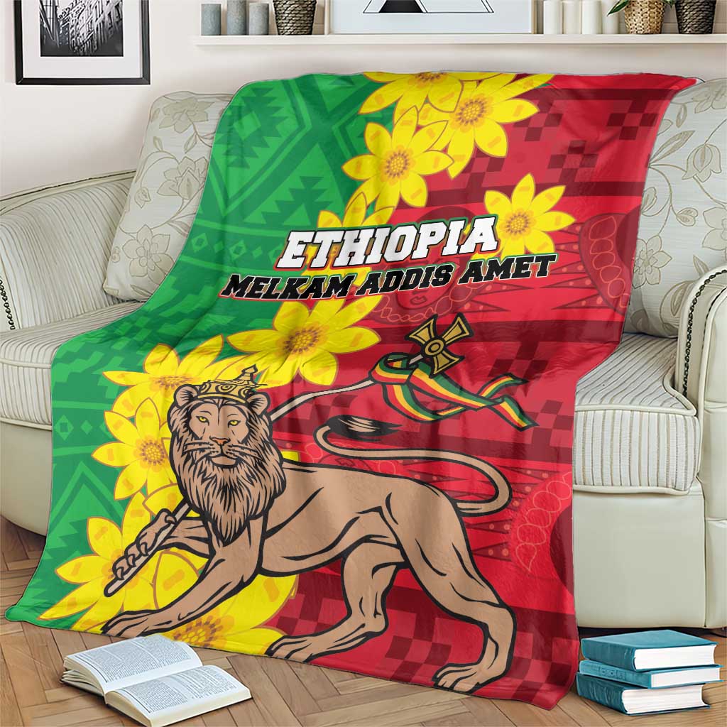 Ethiopia-themed blanket on a sofa arm: green and red checker accents, lion, yellow floral motif