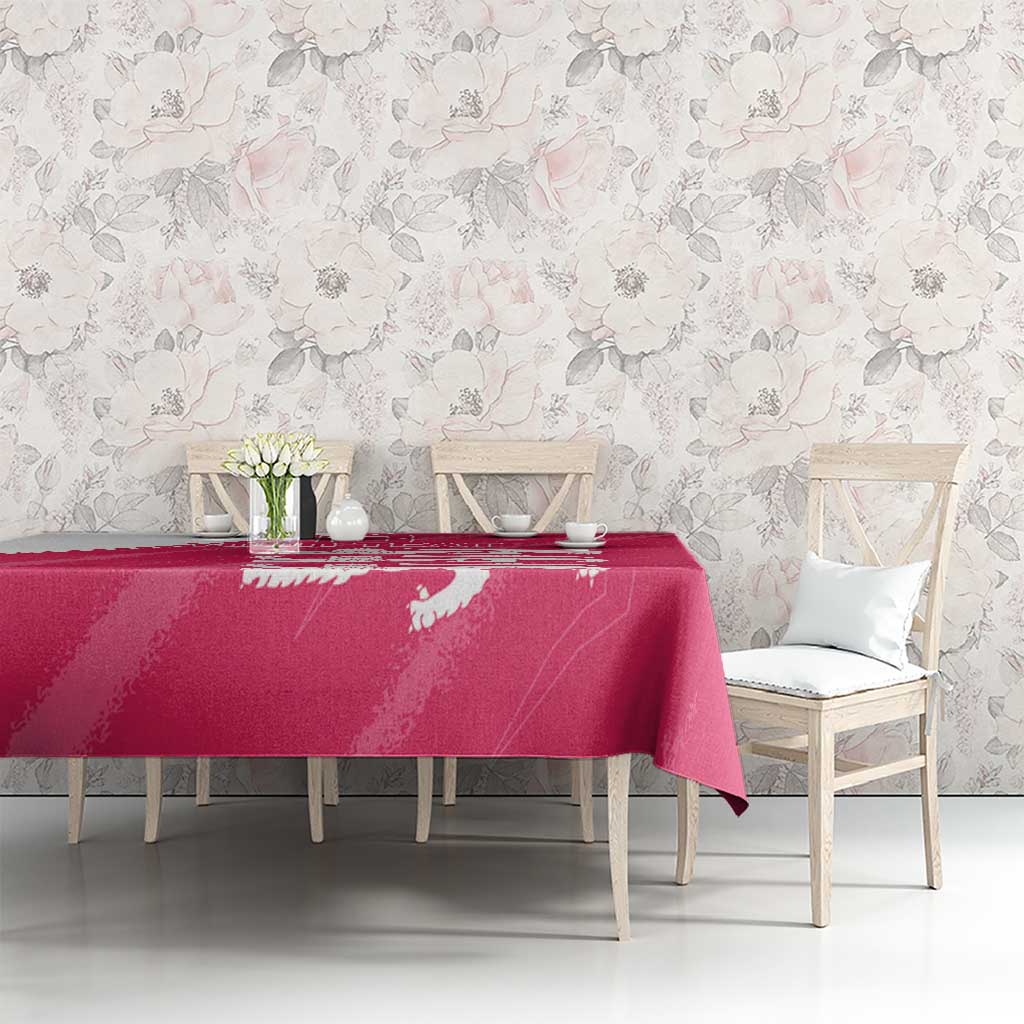 Pink tablecloth with white lion motif on a dining table against floral decor.