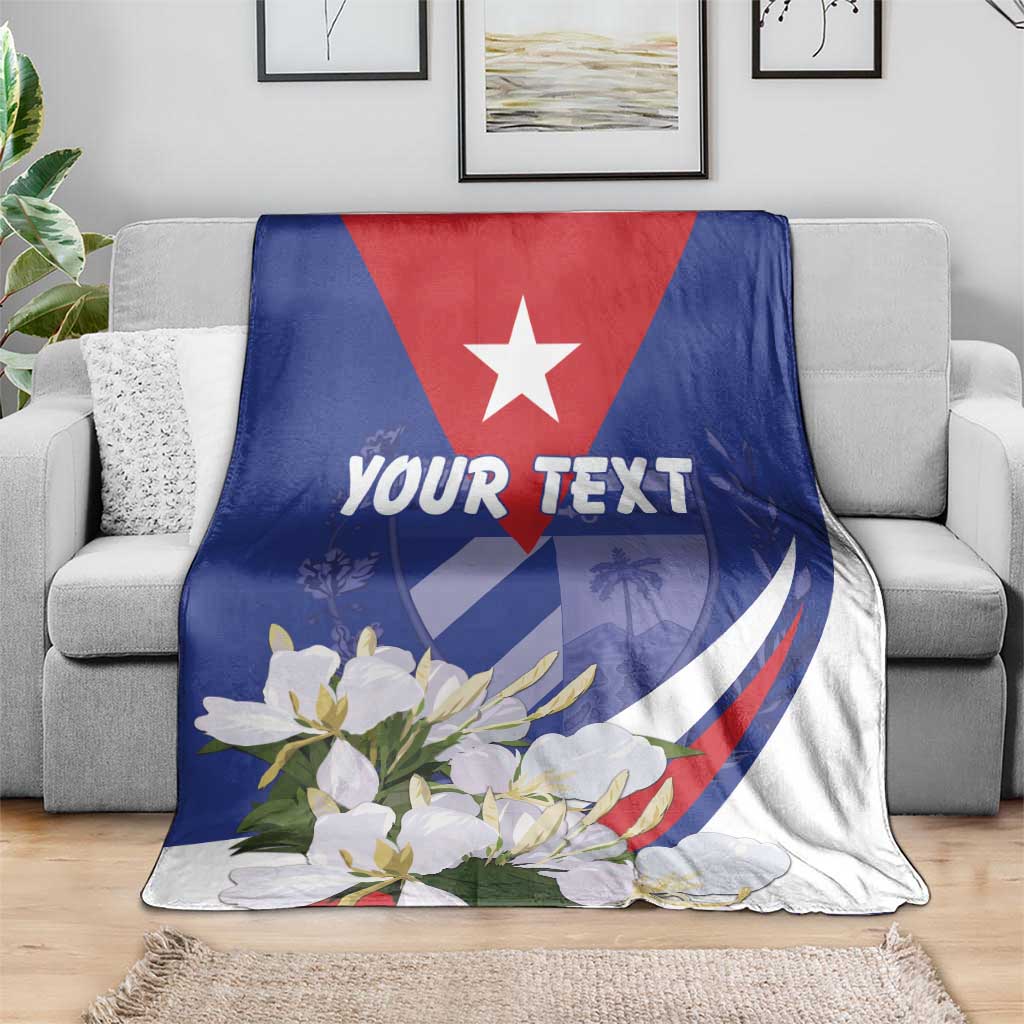 Personalized blanket with white star, flowers, and 'YOUR TEXT' on gray sofa.