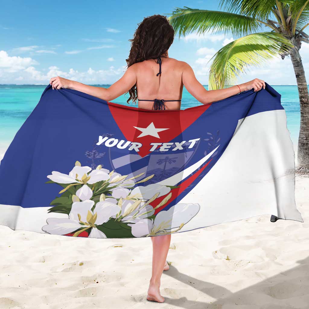 Personalized blue-and-white sarong with red coat of arms and floral print, draped flat