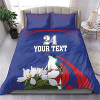 Blue bedding set with duvet and two pillowcases showing bird, white flowers, “24 YOUR TEXT”