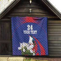 Blue quilt hanging outdoors with red arch stripe, bird and white flowers, custom text