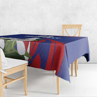 Blue tablecloth draped on rectangular table, red geometric stripes with white bird and flowers